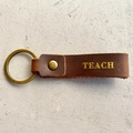Détail du porte-clés en cuir marron avec gravure dorée TEACH pour les enseignants - Style TEACH (2)