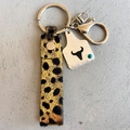 Close-up of leopard print leather keychain with silver bull head tag and turquoise bead - Leopard Print Bull Head Style (4937061546910)