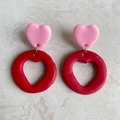 Macro shot of handmade heart-shaped clay drop earrings in vibrant red and pink colors - Hollow Heart Ring