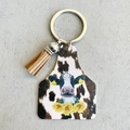 Detail van western lederen sleutelhanger met koeienprint, zonnebloem en bruine kwastjes - Koeprint Zonnebloem Oormerk Stijl (4977195027429)
