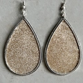 Detail von silbernen Tropfenohrringen mit champagner-goldenem Glitzer und Perlenrand - Champagnergold