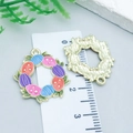 Detail view of colorful enamel Easter wreath pendants with eggs on a scale measuring card - Colorful Egg Wreath (23087) / 1 Piece/Pack (22x20mm)