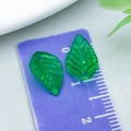 Green acrylic leaf pendants with vein texture and top hole shown on a scale ruler - Green Small Leaf Style