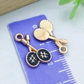 Golden and black enamel badminton racket pendant charms shown on a purple ruler scale - Black Double Badminton Rackets / 20*12mm
