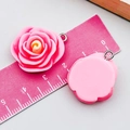 Macro detail of pink resin rose pendant with silver metal loop on measurement scale - Rose Red Camellia (24344) / 25*21*11mm