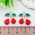 Close-up of red and green cherry charms with silver metal loops for DIY jewelry - Cherry (21935) / 1 Piece/Pack (15x17mm) / Red