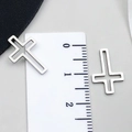 Detailed macro view of silver cutout cross charms for DIY jewelry making near ruler - Cross Style