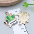 Macro detail of enamel cactus dog charms showing front colorful oil and back woven metal texture - Cactus French Bulldog Style