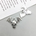 Nahaufnahme von zwei Vintage-Silber-Totenkopf-Fledermaus-Anhängern mit Flügeltexturen - 24*17mm / Altsilber Totenkopf Stil (10873)