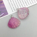 Macro view of shell-shaped resin pendants with colorful sequins and silver glitter detail - Purple Gradient Resin Shell (17047)