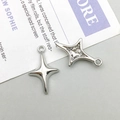 Close-up of silver-tone hollow four-pointed star metal charms for DIY jewelry making - 12*19mm / Silver