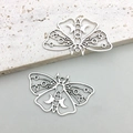 Macro shot of two vintage hollow moth pendants with crescent moon and gothic engravings - Antique Silver Hollow Moth (16929) / 36x22mm