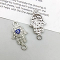 Macro detail of Hamsa Evil Eye pendant with rhinestones and silver alloy texture - Hamsa Hand (14542) / 12*22mm