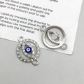 Detailed view of silver evil eye connectors with blue enamel and rhinestones for DIY - Oval Evil Eye (14562) / 19*13mm