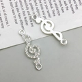 Close-up of silver treble clef jewelry connectors with rhinestones for DIY crafting - Treble Clef Style (14596) / 9x29mm