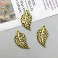 Macro detail of three hollow-out alloy leaf pendants in vintage gold finish for DIY crafts - Antique Gold (10093)
