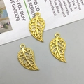 Three gold hollow leaf charms with loop hangers for DIY jewelry making on matte surface - Bright Gold (10094)