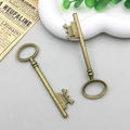 Detail van twee vintage bronzen sleutelhangers voor het maken van doe-het-zelf sieraden - Vintage Sleutel (237) / 23x80mm