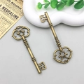 Macro view of vintage bronze alloy key pendants with intricate filigree handles for DIY jewelry - Decorative Vintage Key (3014) / 30x82mm