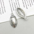 Macro-opname van antieke zilveren rugbyhangers met metalen textuur en kleine ophangringen - Competitieve Rugby Stijl (15722)