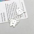 Detail of vintage silver winged tooth charms with smile engravings for DIY jewelry making - Winged Tooth Shape Style