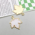 Detailansicht der Ahornblatt-Anhänger mit Metallstruktur und weißem Emaille-Inlay - Weiß