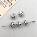 Dettaglio di perle distanziatrici tonde in lega d'argento antico con motivi floreali a rilievo - Perlina Distanziatrice Rotonda Argento Antico 6*8mm (Foro 1.3mm)(16467)
