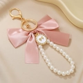 Pink satin bow keychain with white pearl chain and golden decorative butterfly pendant - Pink Bow (ZJ15862)