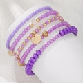 Dettaglio ravvicinato di un set di cinque braccialetti bohémien con perline viola e oro - Combinazione Elastica Sogno Viola (ZJ14645)