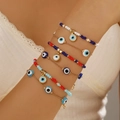 Set di braccialetti Evil Eye multistrato con catena dorata sul polso della modella - Perline di Conteria Multicolore Malocchio (ZJ15086)