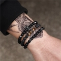 Mens 3-piece beaded bracelet set with black crown charm and natural lava stones on tattooed arm - Crown Tiger Eye Lava Stone Style (ZJ2797)
