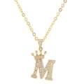 Macro shot of gold letter M pendant with zircon crown decoration and cross chain details - Letter M / Gold