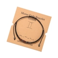 Détail du bracelet Gémeaux en code Morse avec perles de bois et cordon noir sur carte - Gémeaux