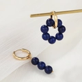 Detail of asymmetric gold earrings with dark blue lapis-like beads on white fabric - Dark Blue Lapis Texture (ZJ6523)