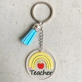 Detail of teacher keychain with blue leather tassel, apple print, and acrylic charm - Pencil Rainbow Teacher Style