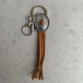 Llavero vintage de cuero estilo vaquero con amuleto de metal grabado sobre un fondo gris - Borla Caramelo Grabado Vintage (2)