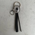 Detalle de llavero vintage vaquero con metal plateado floral y flecos largos de cuero negro - Borla Negra Decoración Piedra Negra (3)