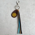 Dettaglio portachiavi in pelle con pendente a girasole e nappe in pelle multicolore - Girasole Giallo
