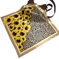 Silky square scarf featuring sunflower and leopard print draped on a leather handbag - Sunflower Leopard Patchwork Style