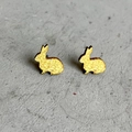 Pendientes de conejo dorado con diseño minimalista sobre fondo de piedra gris - Conejo Brillo Dorado (2)