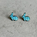 Primer plano de pendientes de madera con forma de conejo azul sobre fondo de piedra - Conejo Manchado Azul (3)