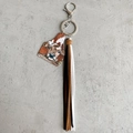 Dettaglio di un portachiavi in pelle stile western con nappe in pelle e mucca - Stile con Motivo Mucca Realistico