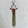 Detalle de llavero estilo western de cuero con cabeza de vaca y borla de leopardo - Leopardo Beige