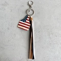 Detail of western cowboy keychain featuring US flag ear tag and long leather tassels - Stars and Stripes Style (1)