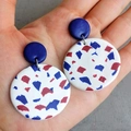 Close-up of handmade polymer clay earrings featuring patriotic terrazzo pattern held in hand - Double Round Terrazzo (Style 7)