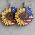 Close-up of wooden sunflower earrings with American flag patterns on a grey stone surface - Flag Sunflower Style