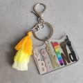 Macro detail of Be Kind acrylic keychain featuring yellow cotton tassels and silver clasp - Transparent Yellow Gradient Tassel (3)