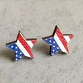 Macro shot of star-shaped wooden earrings featuring American flag patterns on a grey base - Star Style