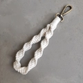 Macro shot of boho cream macramé keychain showing detailed spiral hand-woven cotton texture - Spiral Braid Style / Milky White