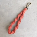 Detail of handmade boho macramé wristlet keychain in burnt orange with spiral knot - Spiral Braid Style / Terracotta Red